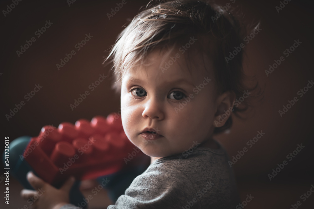 Obraz na płótnie Portret małej dziewczynki bawiącej się klockami w salonie