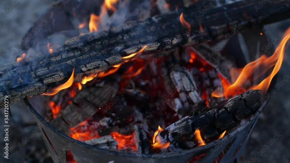 Slow motion of a fire pit burning wood to crisp, the fire is well underway helping to eliminate old wood and belongings, a lot of smoke and sparks fly off the wood in pit so hot creating loads of heat Slow motion of a fire pit burning wood to crisp, the fire is well underway helping to eliminate old wood and belongings, a lot of smoke and sparks fly off the wood in pit so hot creating loads of heat