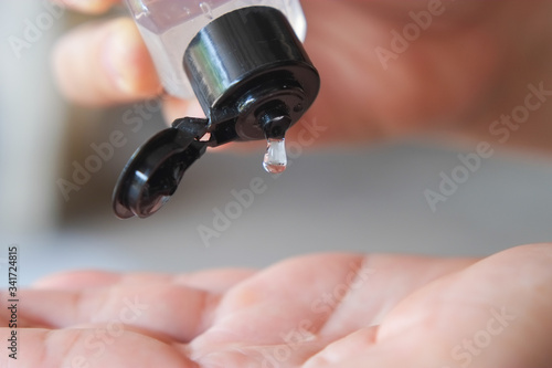 Wallpaper Mural Alcohol gel from plastic bottle is dripping on their hands to clean and kill germs close-up. Torontodigital.ca