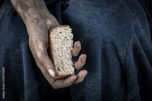 dirty women's hands with a piece of bread, poverty, hunger