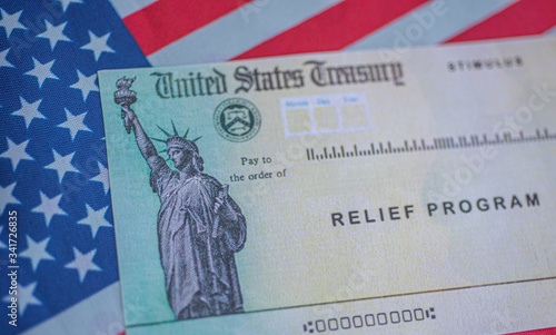  COVID-19 economic Stimulus check on blurred background. Relief program concept.