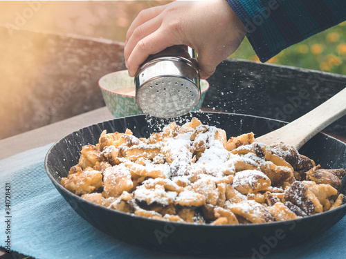 kaiserschmarrn with powdered sugar - using sugar shaker
