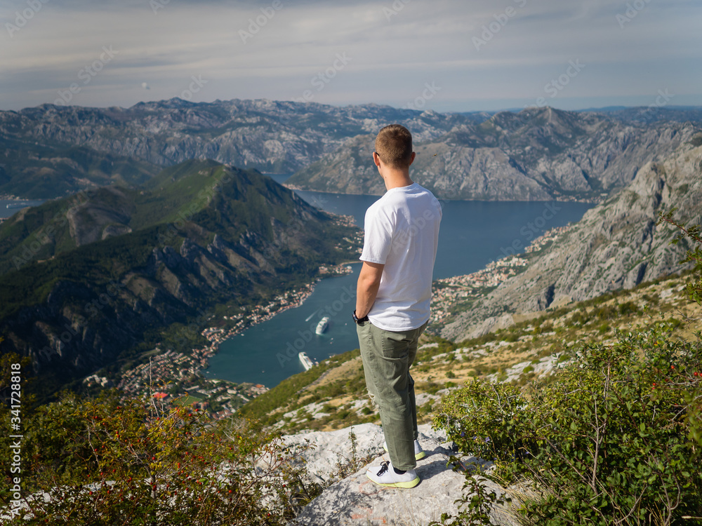 Boy admires the view of the Kotor Bay from the Kotor serpentine. Montenegro autumn 2019