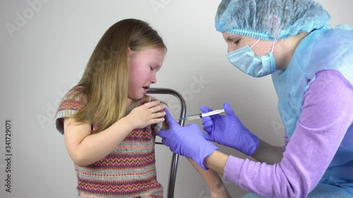 A doctor injects a vaccine to a little girl. The girl is afraid and crying. 4k