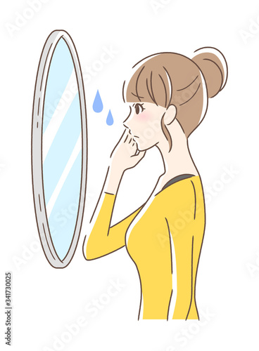 不安な表情で鏡を見る女性