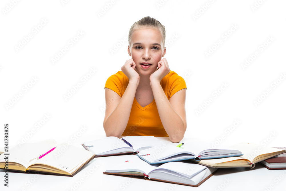Educational Ideas. Portrait of Exhausted Caucasian Teenager Girl Posing with Lots of Books. Isolated On White Educational Ideas. Portrait of Exhausted Caucasian Teenager Girl Posing with Lots of Books. Isolated On White