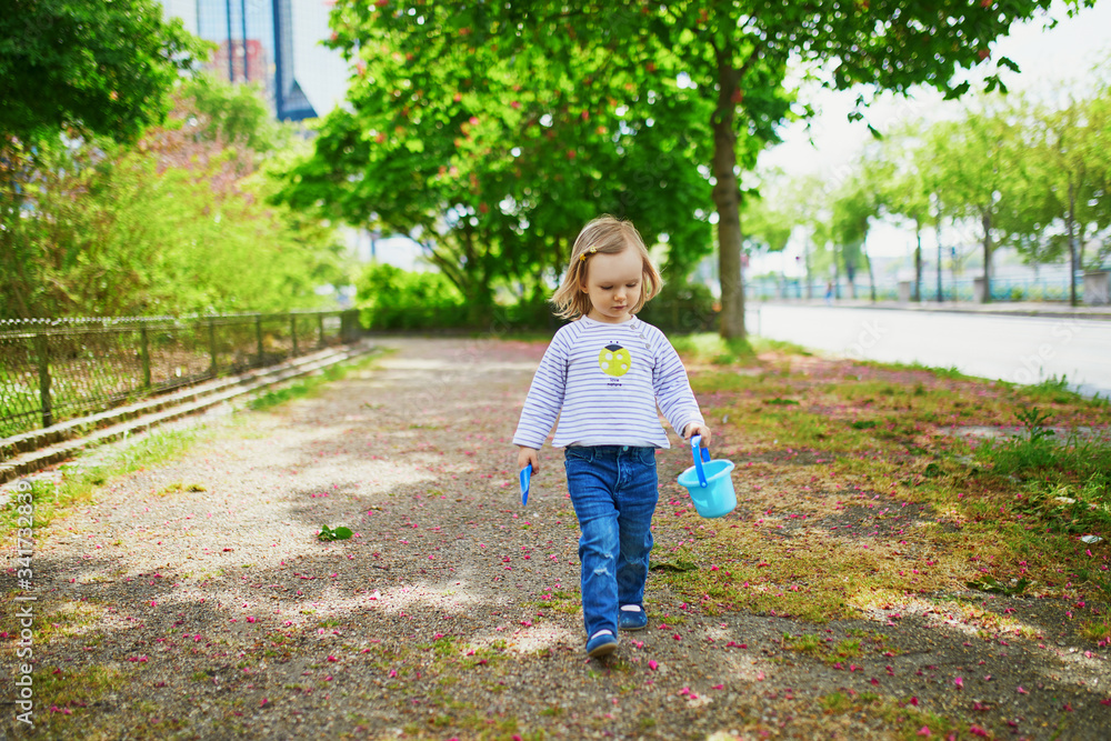 Adorable toddler girl playing with bucket and shovel Adorable toddler girl playing with bucket and shovel