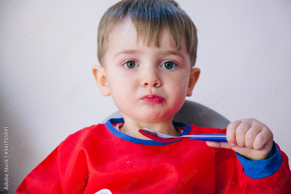 little blonde caucasian kid eating at home. Family and healthy diet lifestyle. little blonde caucasian kid eating at home. Family and healthy diet lifestyle.