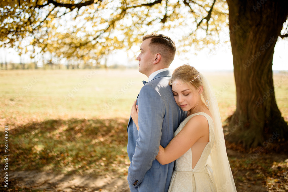 Young beautiful couple hugging in their wedding dresses in autumn park. Young beautiful couple hugging in their wedding dresses in autumn park.
