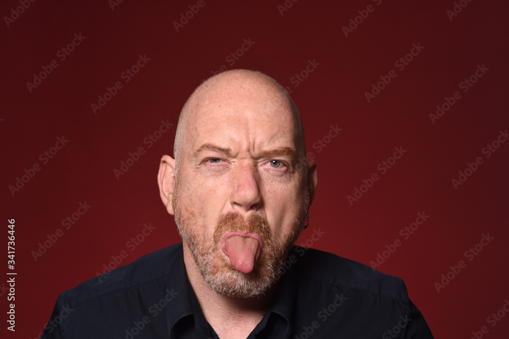 man with tongue on red background