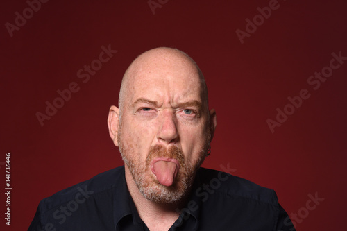 man with tongue on red background