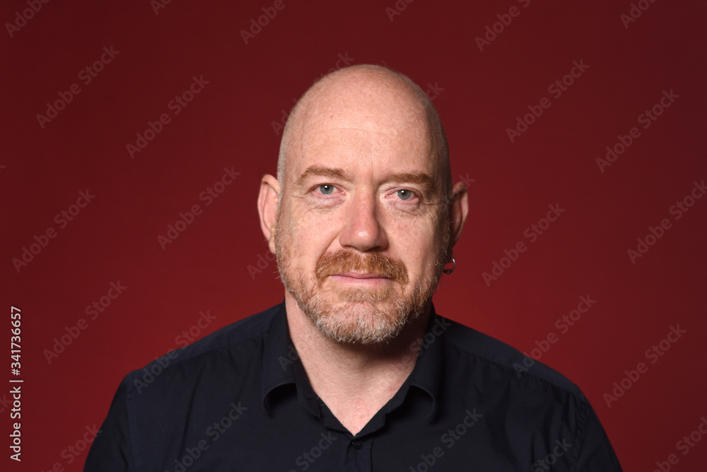 portrait of a bald man on red background portrait of a bald man on red background