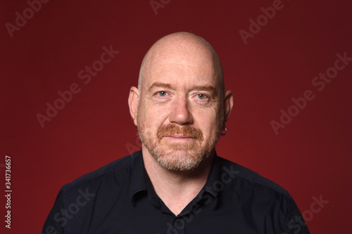 portrait of a bald man on red background