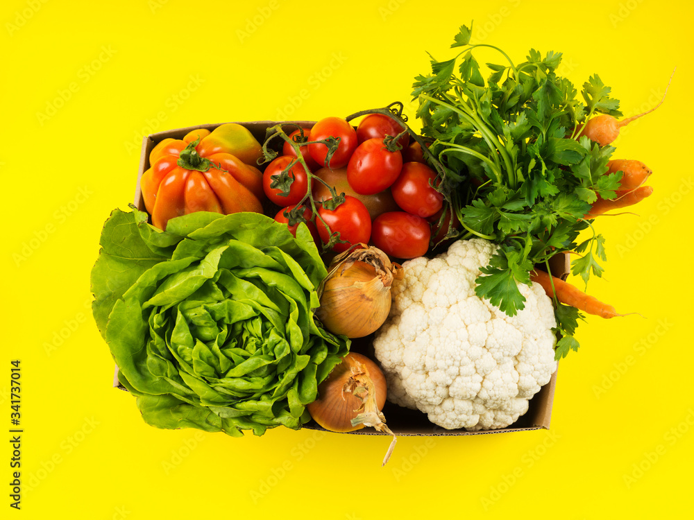 Fresh produce, food staples delivery or donation box concept on yellow background. Fresh produce, food staples delivery or donation box concept on yellow background.