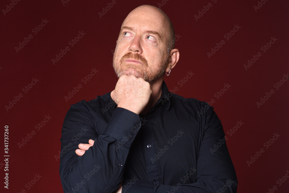 man with hand on chin on red background