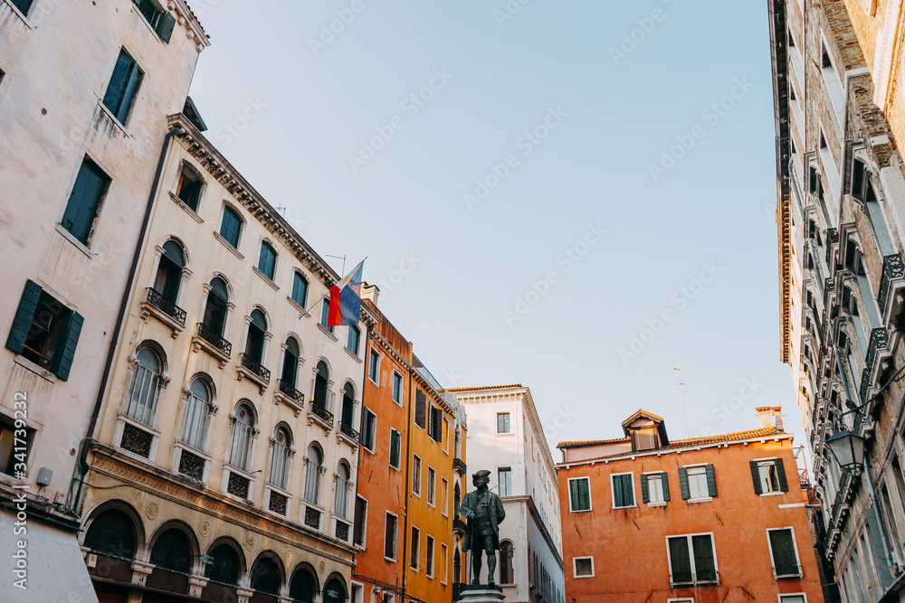 Monument to the playwright Carlo Goldoni on the background of colorful houses | VENICE, ITALY - 16 SEPTEMBER 2018.