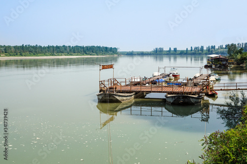 Fototapeta Naklejka Na Ścianę i Meble -  Traditional fishing boats tied up on the floating dock in picturesque surrounding of the big river