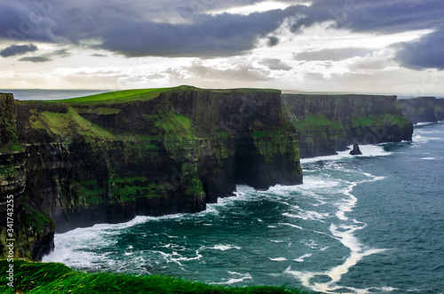 Dramatic landscape featuring majestic cliffs, dark blue ocean and natural cloudy sky - Ireland Cliffs of Moher