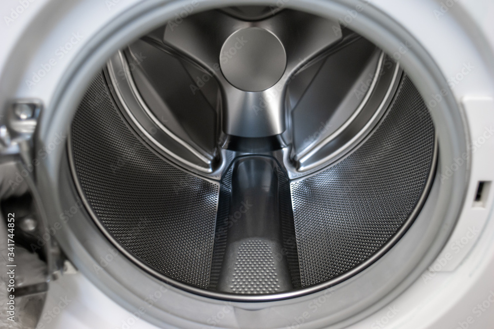 Washing machine open door silver metal empty tumbler close up shot Washing machine open door silver metal empty tumbler close up shot
