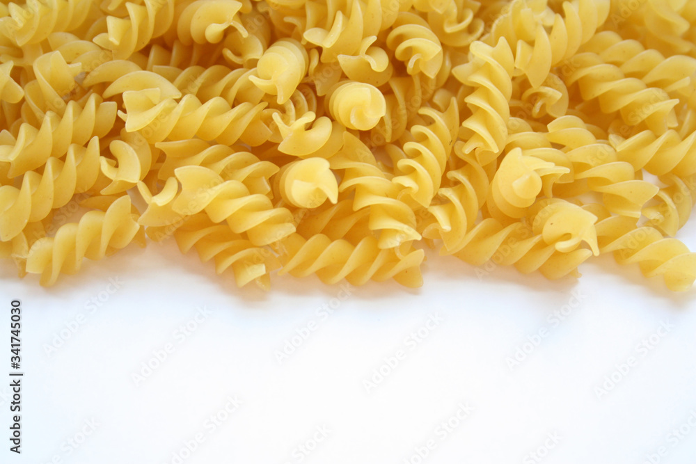 Twisted pasta lie on a white background. Close-up. Twisted pasta lie on a white background. Close-up.