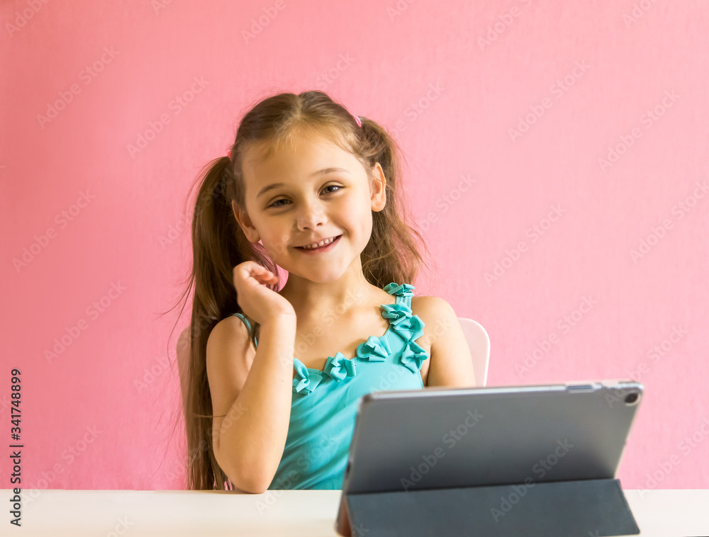 little girl with a tablet at the table little girl with a tablet at the table