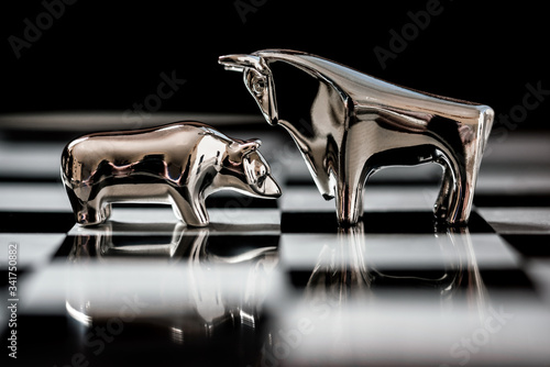 silver bull and bear on a chessboard close up