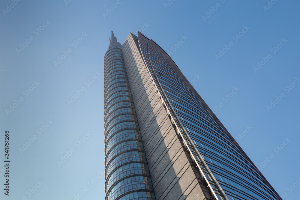 A huge multi-story modern office building against a blue sky. 01.2020 Milan A huge multi-story modern office building against a blue sky. 01.2020 Milan