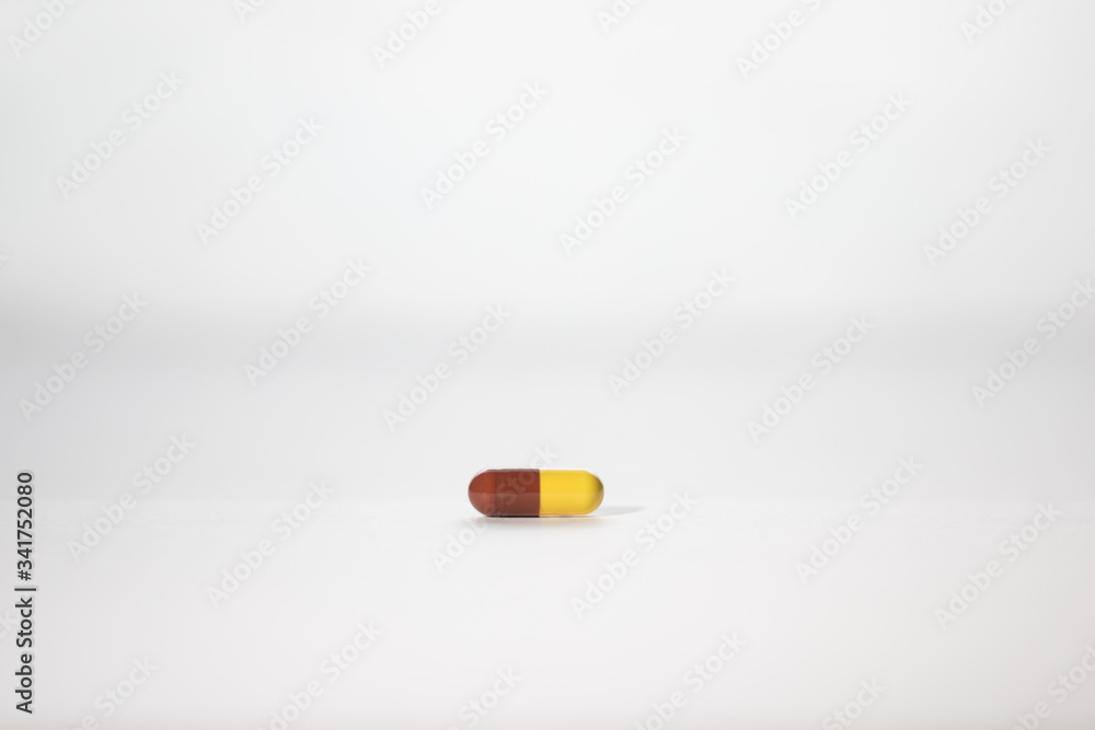 brown and yellow pill isolated on white background brown and yellow pill isolated on white background