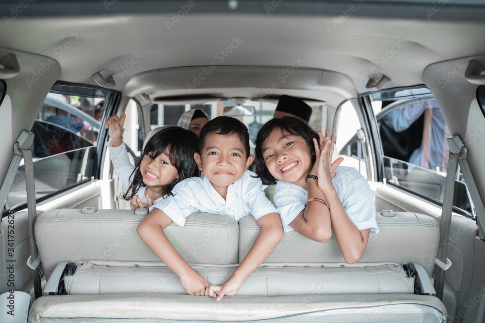 happy three children excited to go on holiday with family. shoot from behind the car happy three children excited to go on holiday with family. shoot from behind the car