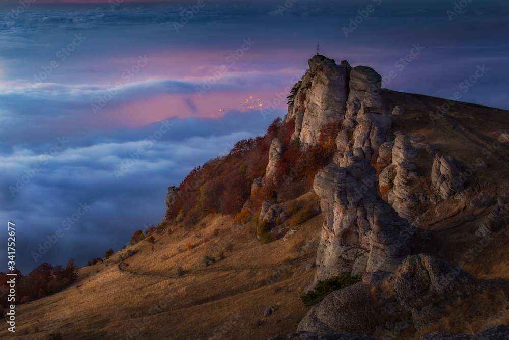 Mountain landscape at sunrise with beautiful cliffs and fog on the horizon