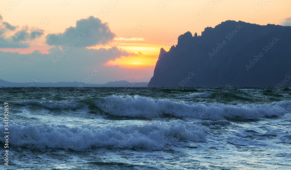 Sea landscape with two waves and a mountain on a cloudy day