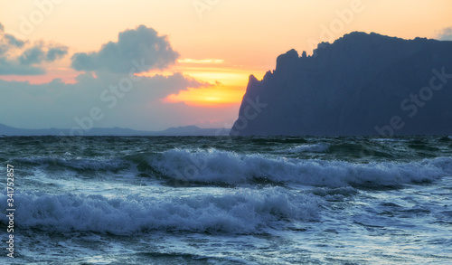 Sea landscape with two waves and a mountain on a cloudy day