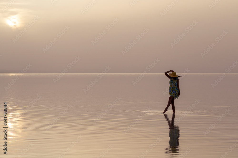 Woman walking at sea at sunset. Beach Summer Holiday Vacation Traveling Relaxation Concept 