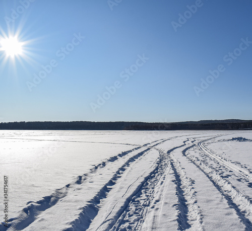 Most beautiful winter landscape. Snowy road. Bright sun over the winter lake. Place for text. © Natalya