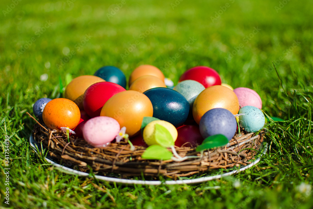 Easter eggs pictured in a wooden basket on green grass. Easter eggs pictured in a wooden basket on green grass.