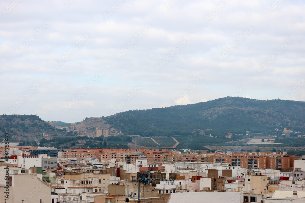 view to the roofs of the city of Sagunto, Spain with mountains on the background