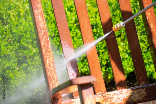 A power washer washing a chair