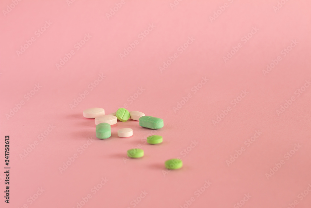Colored pills on neutral pink background. Drugs for legal use.
