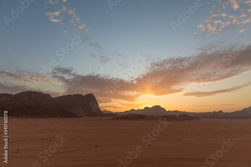 Incredible sunset in the Wadi Rum desert. The blue sky is covered with cirrus clouds. View from the cliff