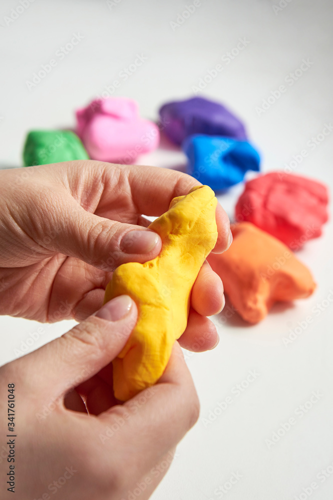 The hand of a girl who sculpts from light airy multi-colored plasticine. The hand of a girl who sculpts from light airy multi-colored plasticine.