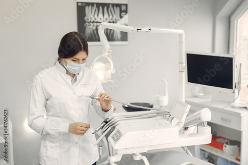 Woman in a uniform. Doctor working at the clinic. Dentist holds a tools in her hands