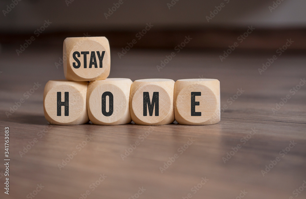 Cubes and dice with words stay home on wooden background