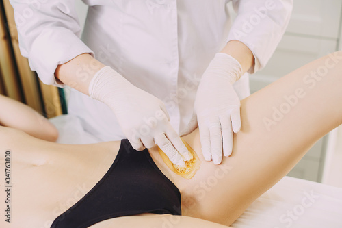 Bikini depilation waxing. The master makes hair removal in the salon