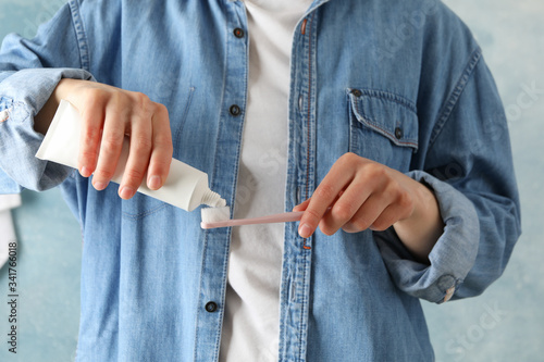 Woman squeezes toothpaste, front view. Dental care