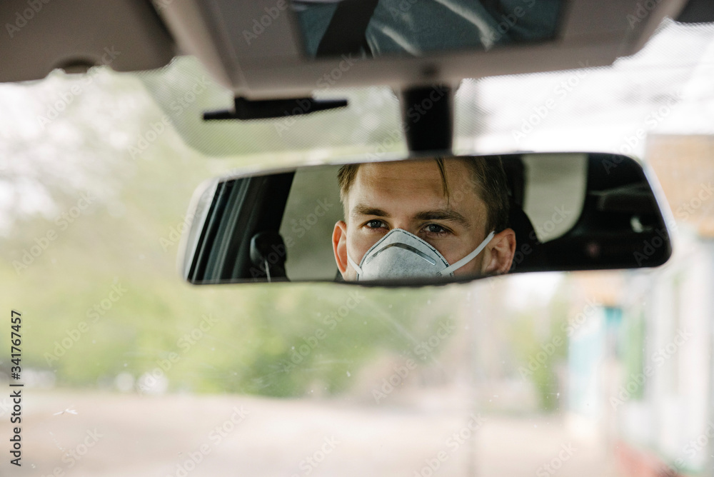 a male driving car wearing protective face mask and gloves a male driving car wearing protective face mask and gloves