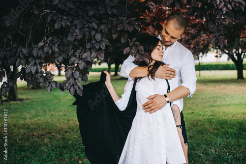 A porttret of a young caucasian stylish couple walking on beautiful park photo