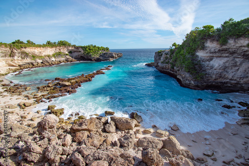 Tropical beach landscape with light blue water and rocks