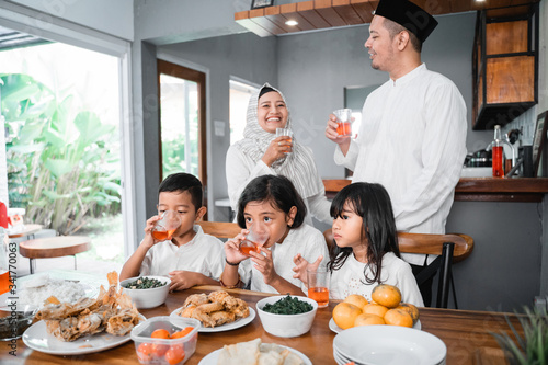 thristy family drinking sweet drink for breaking the fast on ramadan month photo