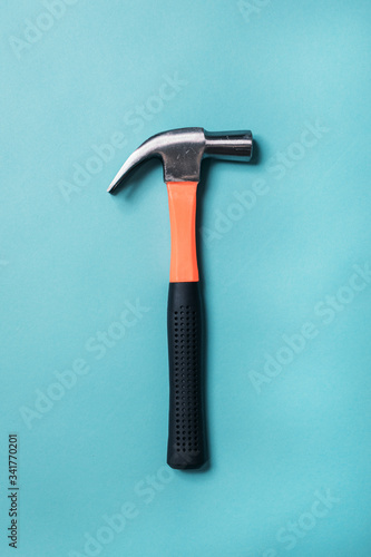 metal hammer with an orange handle on a blue background close