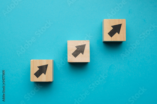 Financial growth concept with icons on wooden blocks.